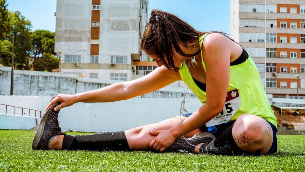 a female runner doing a seated hamstring stretch