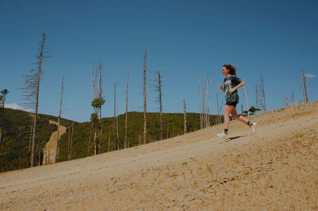 Woman running downhill doing assisted speed training