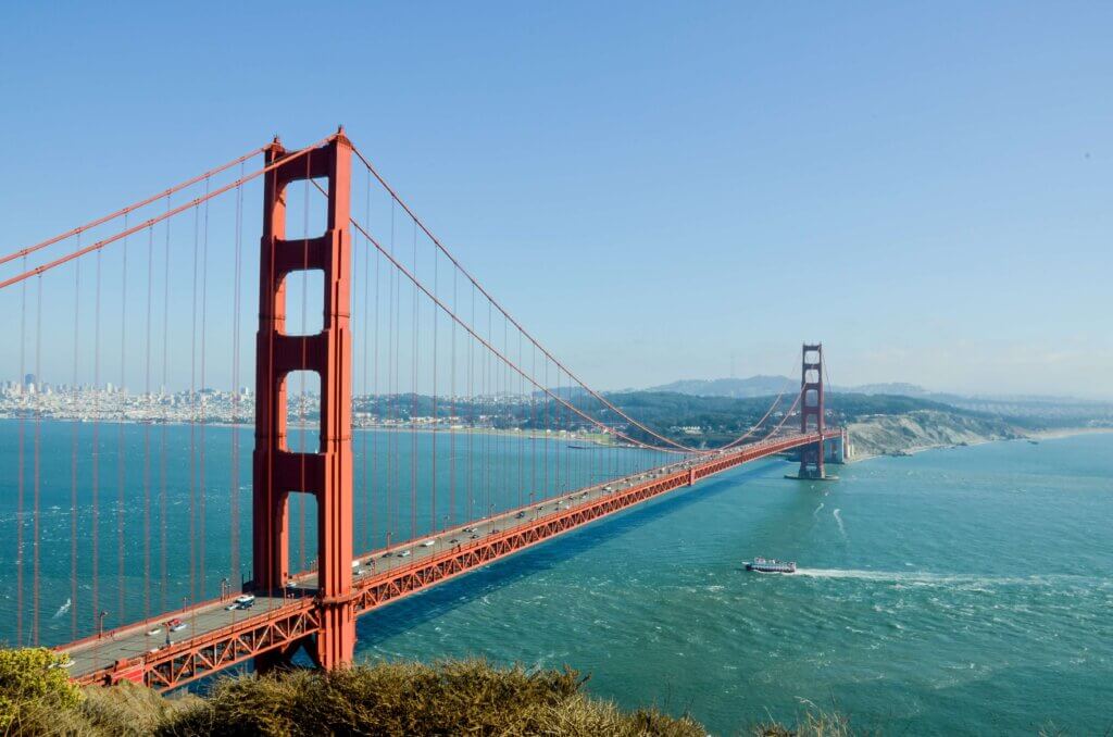 Picture of the Golden Gate Bridge in San Francisco with a barge sailing underneath.