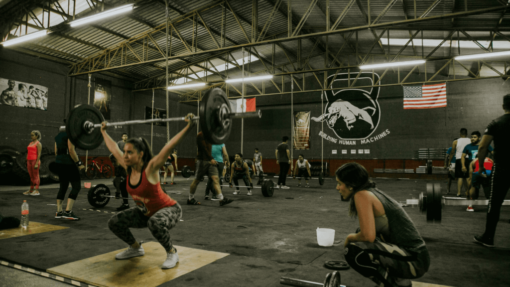 Photo of a gym with a bunch of people training on deadlifts