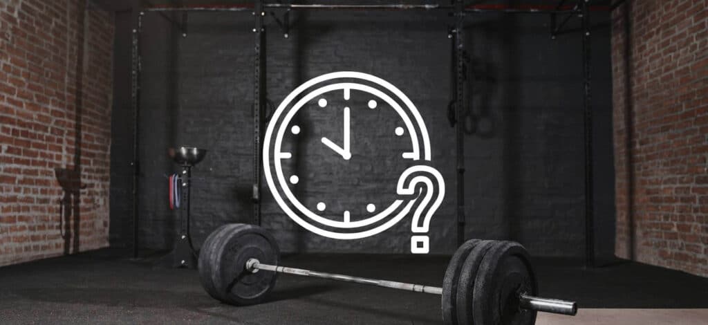 A cross-fit gym with brick walls and a barbell laid across the floor. There is an image overlay of a clock with a small question mark overlay.